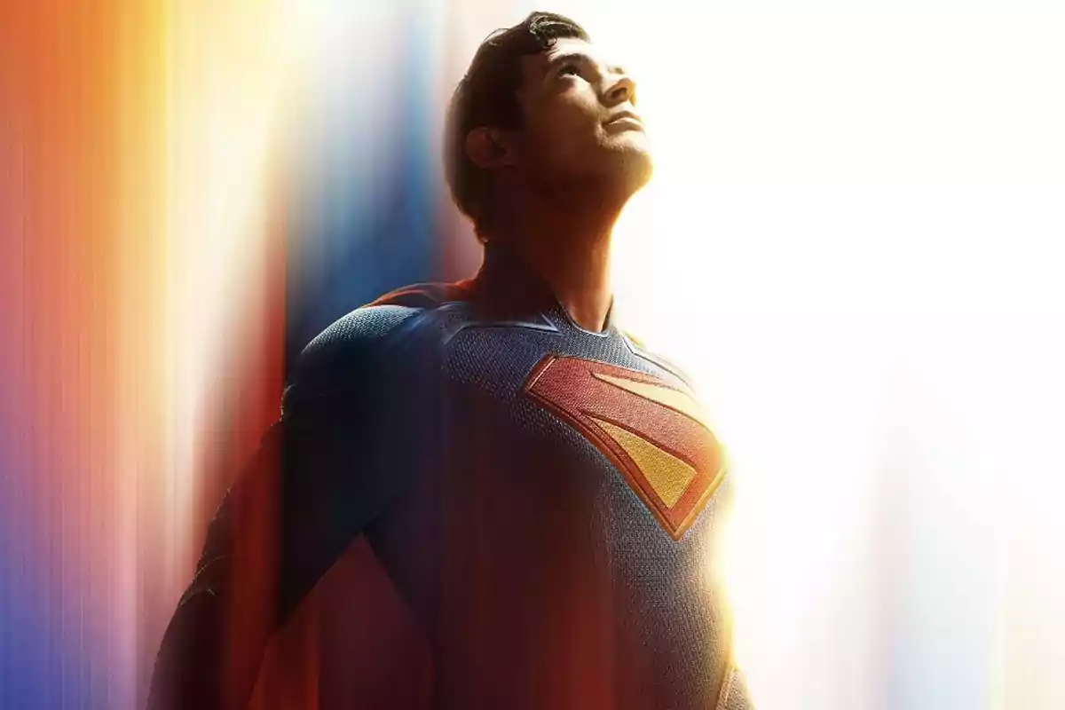 Superhero in a blue suit and red cape looking up with a bright light in the background Superhero in a blue suit and red cape looking up with a bright light in the background
