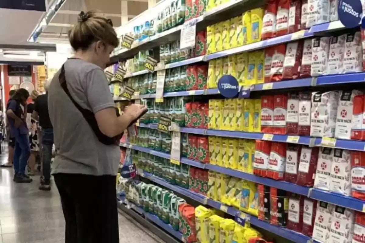 Woman looking at packages of yerba mate on a supermarket shelf