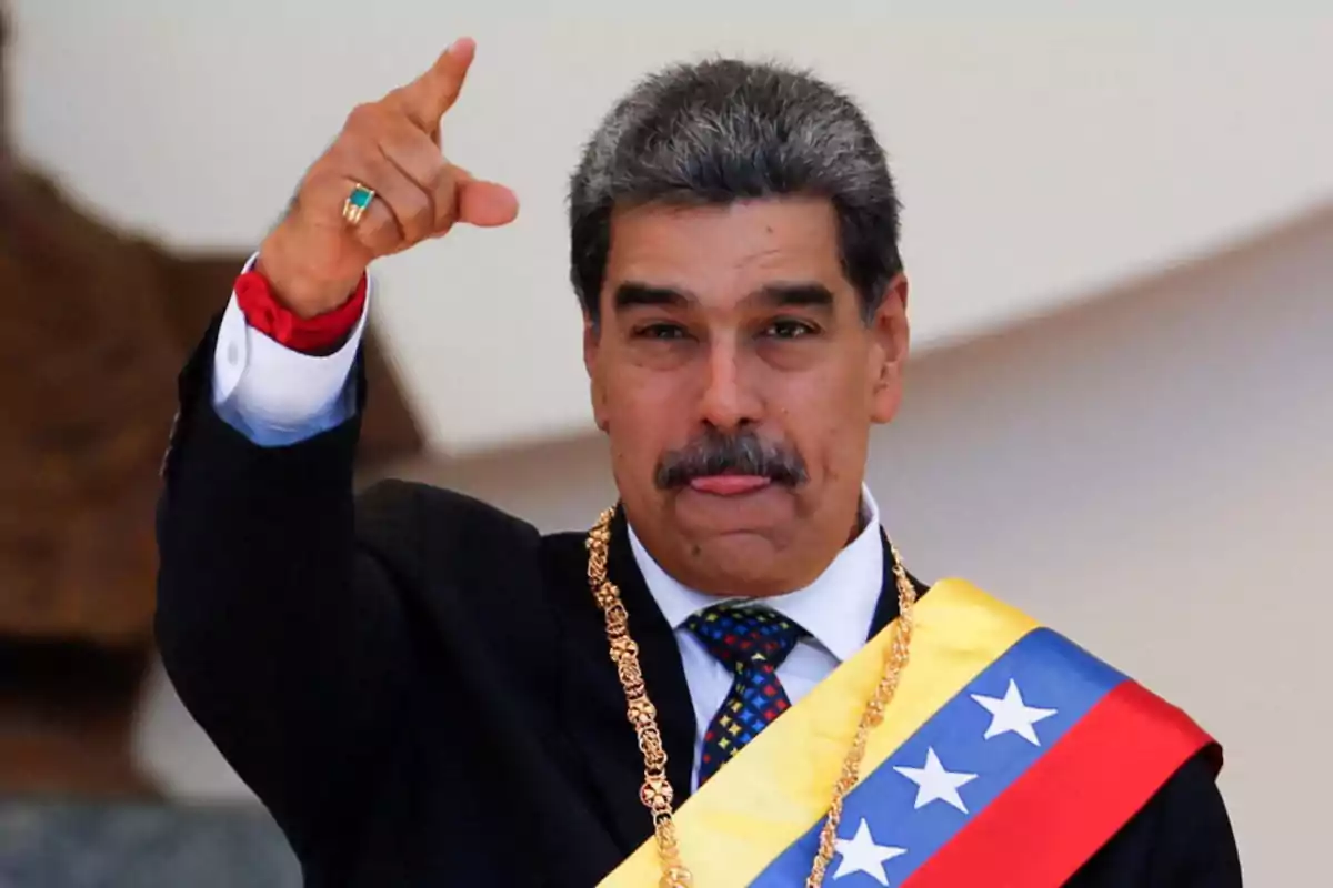 Man with a mustache wearing the Venezuelan presidential sash and pointing with his hand