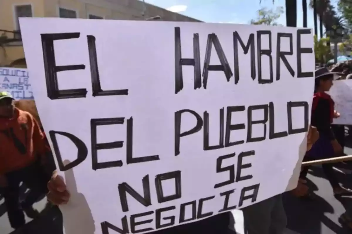 Person holds a sign at a protest that says the people's hunger is not negotiable