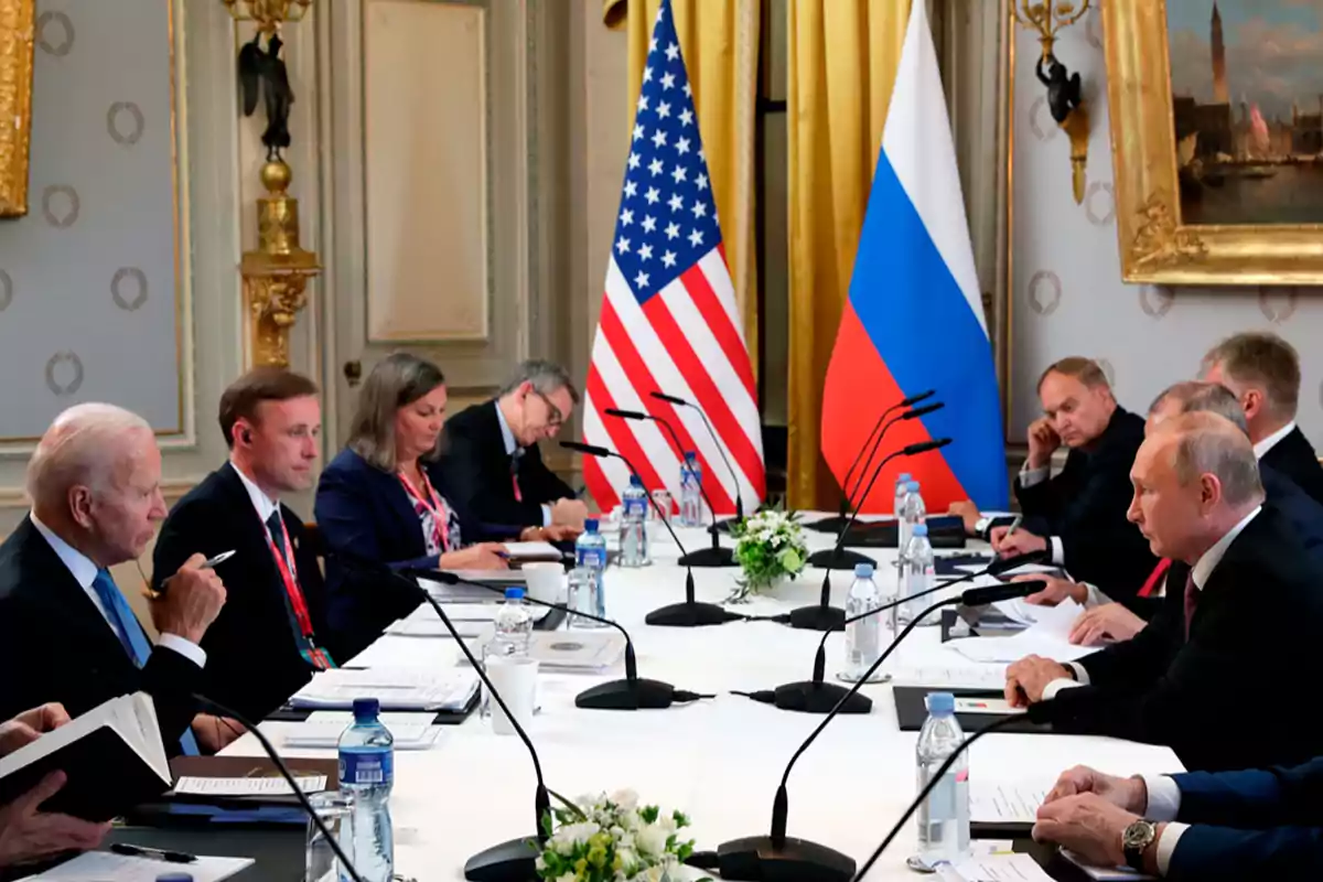 Reunión diplomática entre delegaciones de dos países con banderas de Estados Unidos y Rusia en la mesa.