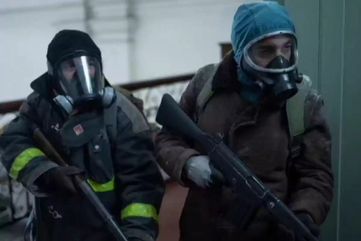 Two people wearing gas masks and warm clothing hold weapons while indoors. Two people wearing gas masks and warm clothing hold weapons while indoors.