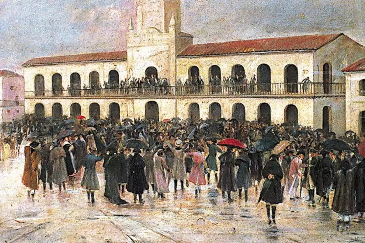 Crowd of people gathered in front of a colonial building with balconies and a tiled roof, many of them carrying umbrellas and wearing period clothing. Crowd of people gathered in front of a colonial building with balconies and a tiled roof, many of them carrying umbrellas and wearing period clothing.