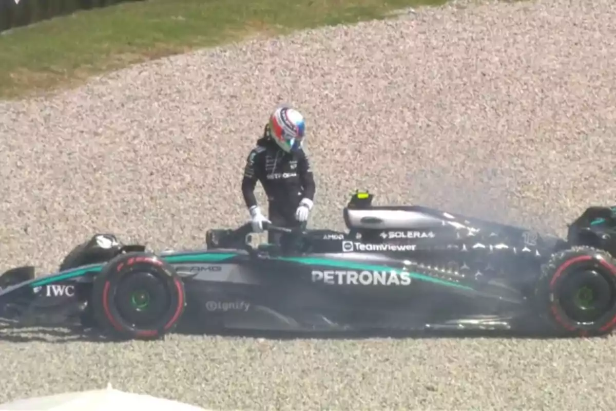 Formula 1 driver getting out of his Mercedes single-seater stopped in the gravel during a race Formula 1 driver getting out of his Mercedes single-seater stopped in the gravel during a race