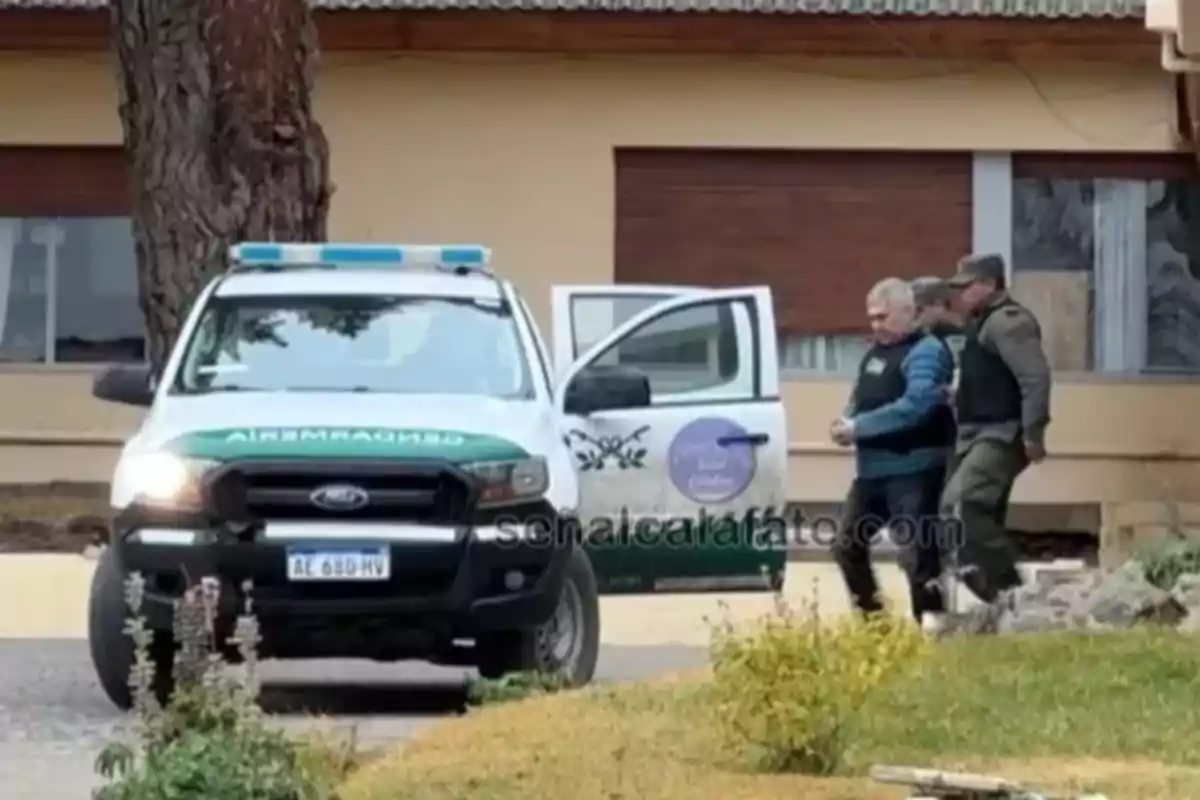 Un hombre escoltado por un agente de seguridad es llevado hacia una camioneta oficial estacionada frente a un edificio. Un hombre escoltado por un agente de seguridad es llevado hacia una camioneta oficial estacionada frente a un edificio.