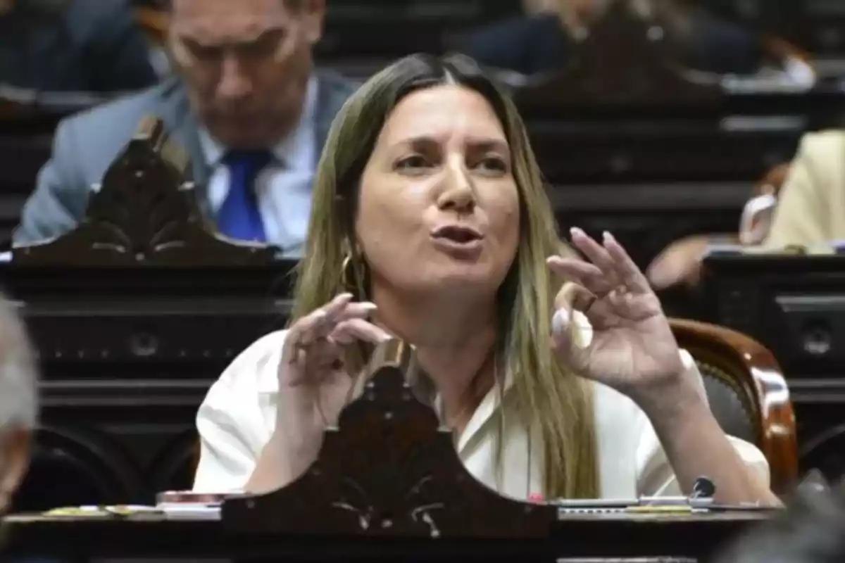 Mujer hablando y gesticulando durante una sesión en un recinto legislativo Mujer hablando y gesticulando durante una sesión en un recinto legislativo