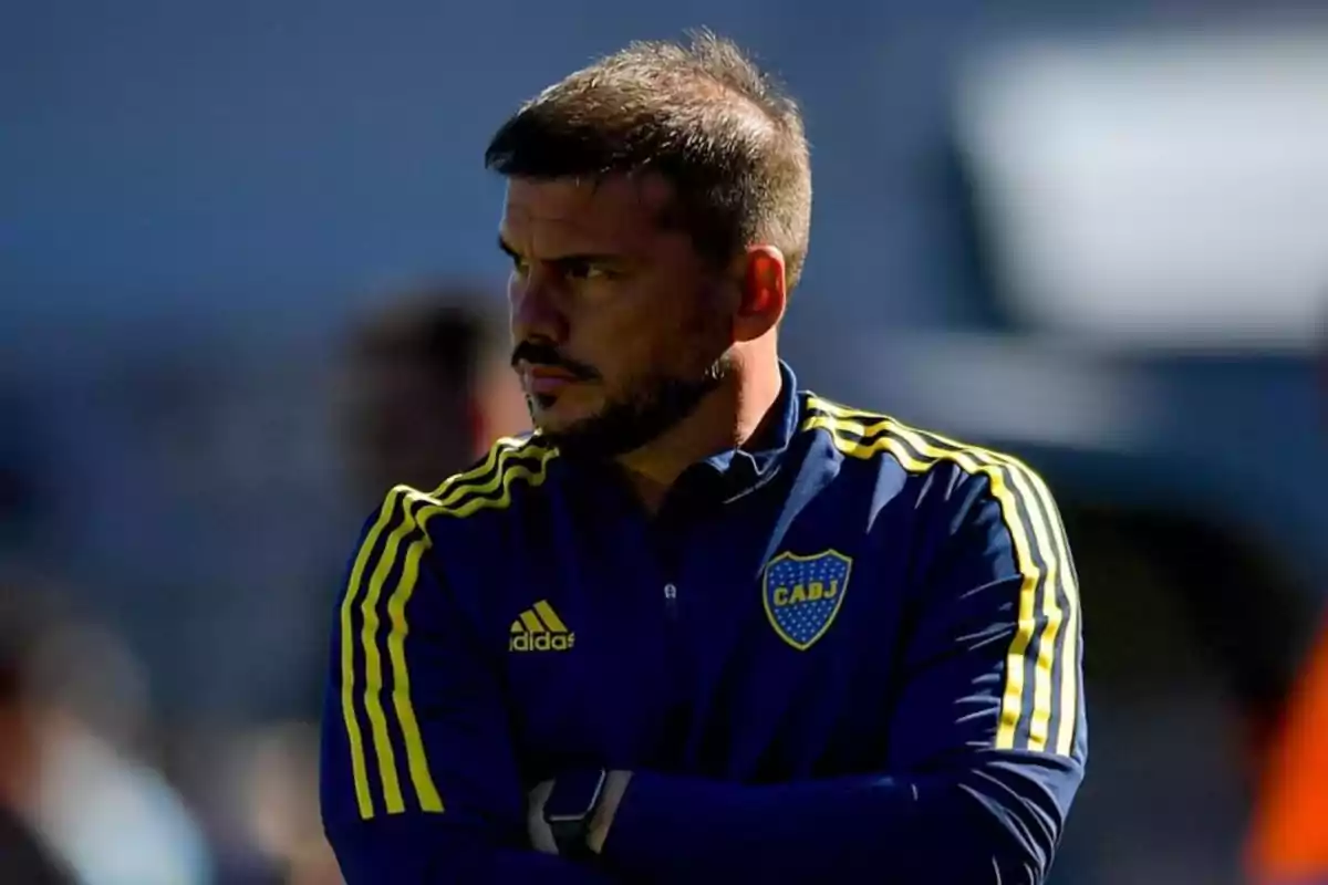 Man wearing a blue Boca Juniors jacket with yellow details, looking to the left with a serious expression Man wearing a blue Boca Juniors jacket with yellow details, looking to the left with a serious expression