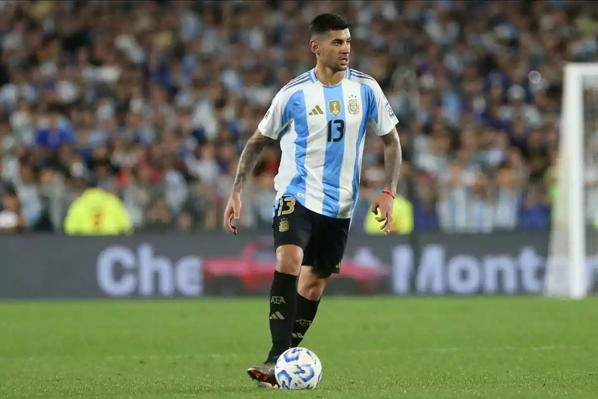 A player in the Argentina uniform controls the ball on the field during a match. A player in the Argentina uniform controls the ball on the field during a match.