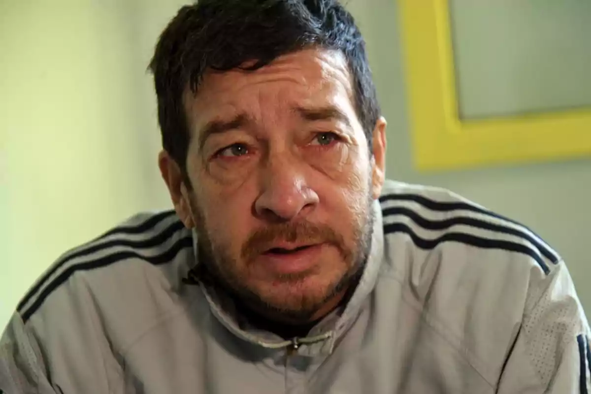 Short-haired, bearded man with a serious expression and red eyes wears a gray sports jacket with black stripes. Short-haired, bearded man with a serious expression and red eyes wears a gray sports jacket with black stripes.
