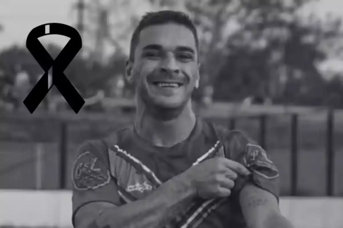 Smiling player in a black and white photo with a black mourning ribbon in the top left corner