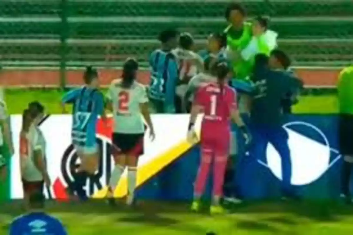 Jugadoras de fútbol discuten en el campo durante un partido.