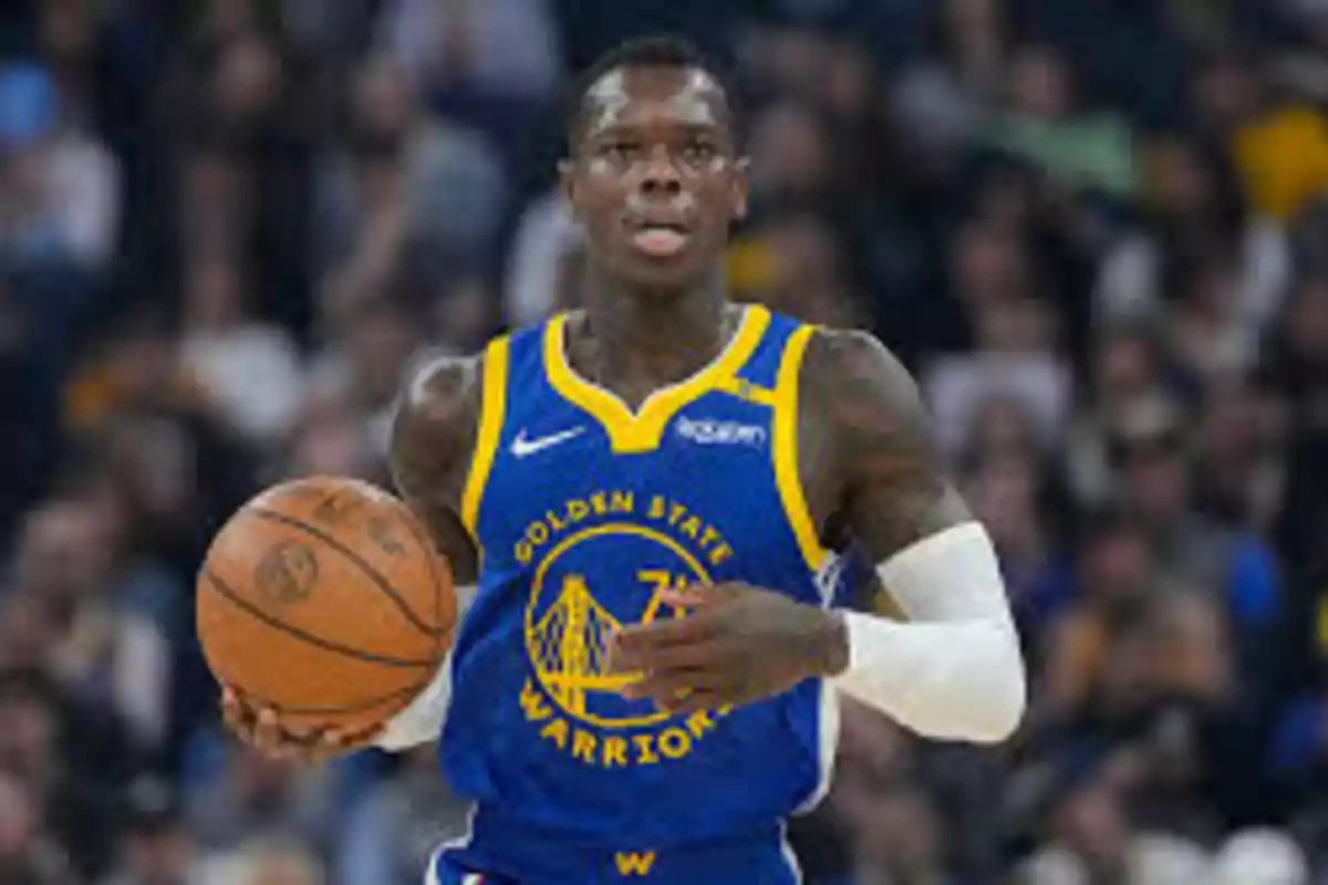 Jugador de baloncesto con uniforme de los Golden State Warriors sosteniendo un balón durante un partido.