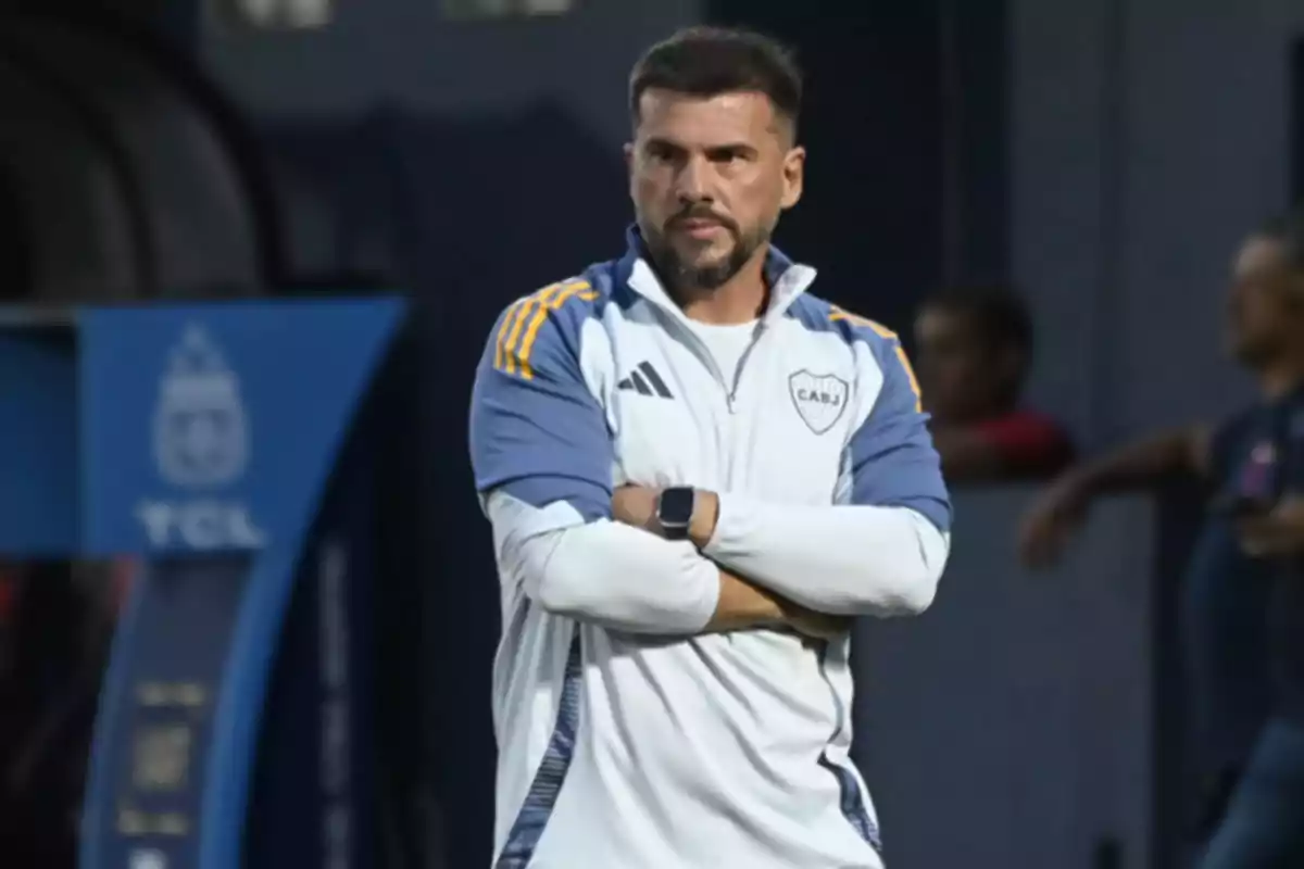 Soccer coach wearing a Boca Juniors jacket watching the game with his arms crossed