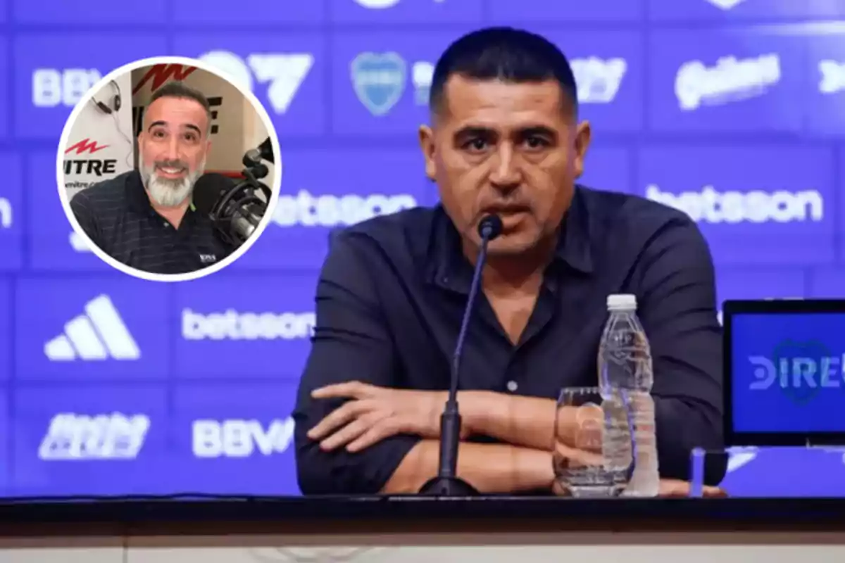 A man at a press conference with a microphone in front of him and a bottle of water on the table, with an inset showing another person smiling in front of a microphone.