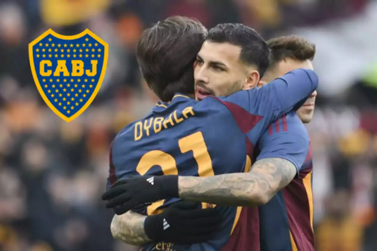 Two players hug on the field while wearing blue and maroon jerseys; in the background, the Boca Juniors crest can be seen.