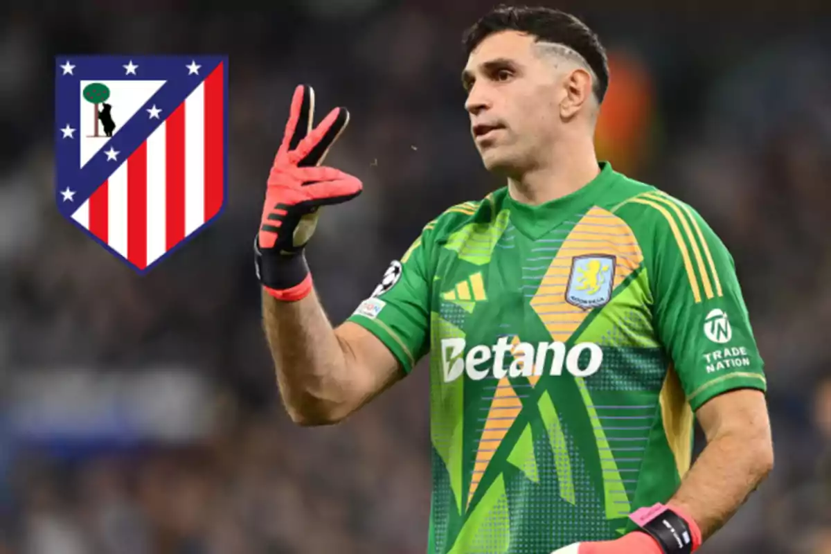 Un jugador de fútbol con uniforme verde y guantes rojos hace un gesto con la mano, mientras el escudo del Atlético de Madrid aparece en el fondo.