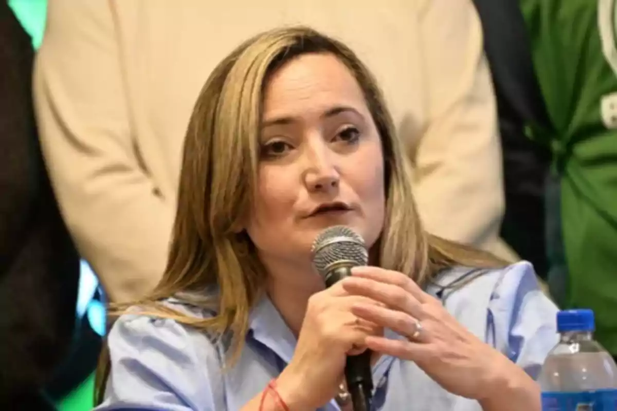 Mujer hablando en un micrófono durante una conferencia de prensa.