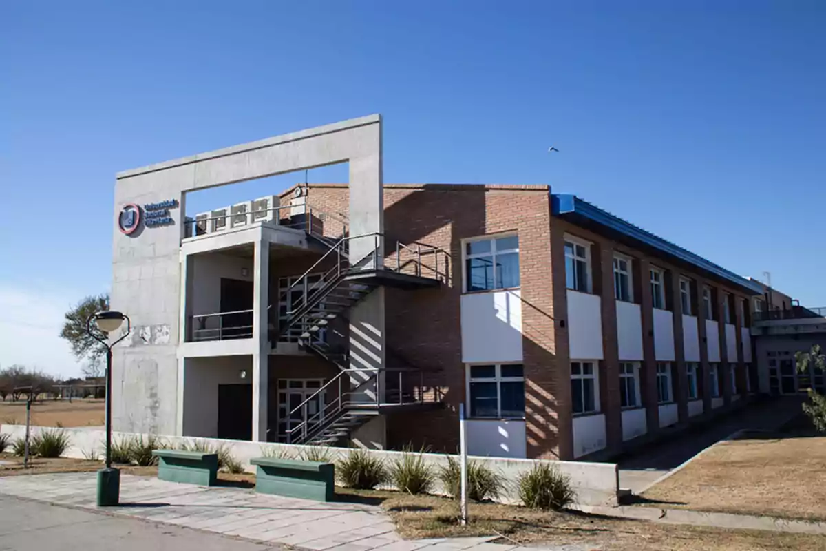 Edificio moderno de dos pisos con paredes de ladrillo y concreto, escaleras exteriores de metal, ventanas grandes y un cielo despejado Edificio moderno de dos pisos con paredes de ladrillo y concreto, escaleras exteriores de metal, ventanas grandes y un cielo despejado