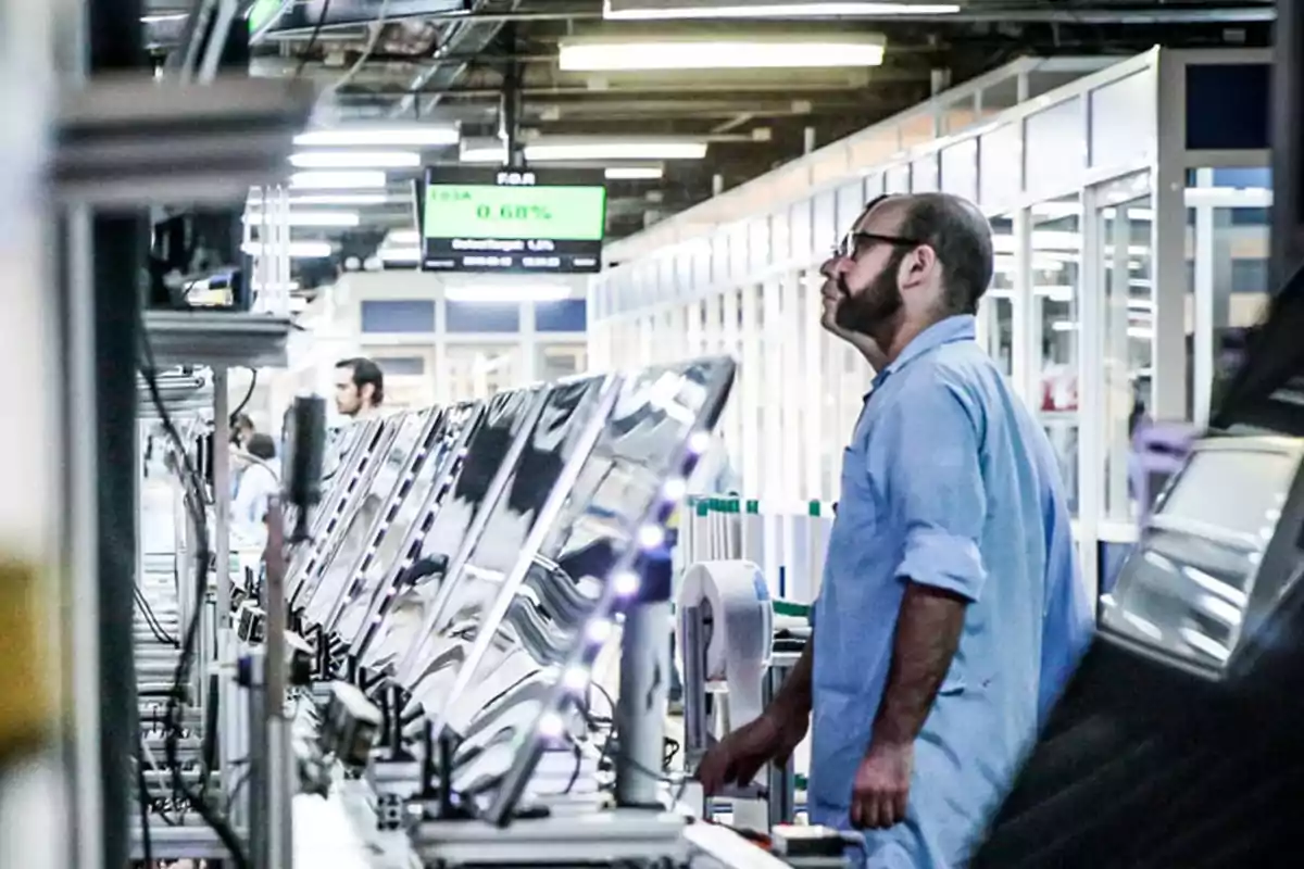 Man in a factory observing an electronic display production line. Man in a factory observing an electronic display production line.