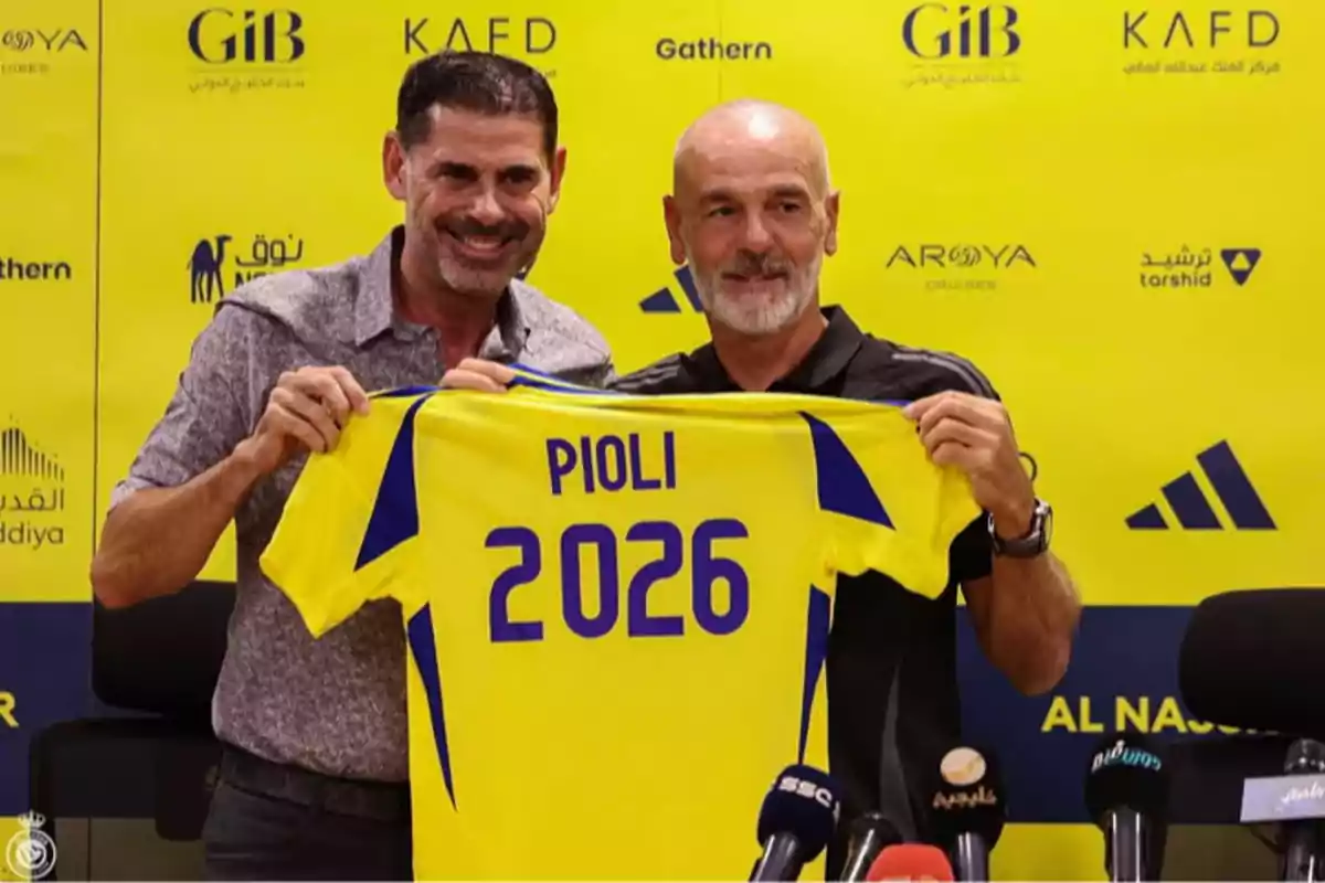 Dos hombres sonríen mientras sostienen una camiseta amarilla con el nombre Pioli y el número 2026 frente a un fondo con logotipos y marcas. Dos hombres sonríen mientras sostienen una camiseta amarilla con el nombre Pioli y el número 2026 frente a un fondo con logotipos y marcas.