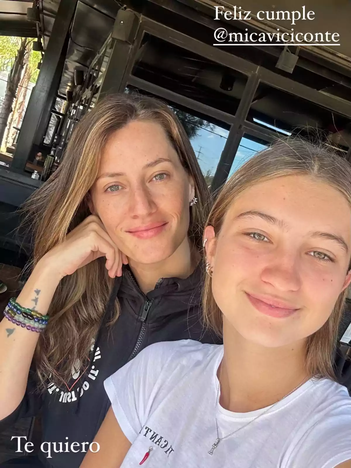 Two people smile while posing for a selfie in an outdoor setting, one wearing a black sweatjersey and the other a white t-jersey. Two people smile while posing for a selfie in an outdoor setting, one wearing a black sweatjersey and the other a white t-jersey.