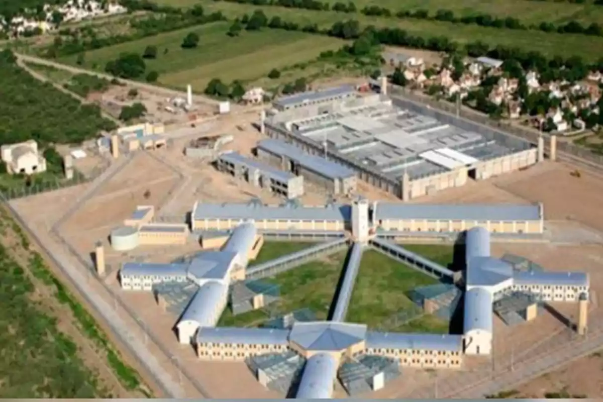 Aerial view of a prison complex surrounded by green areas and roads Aerial view of a prison complex surrounded by green areas and roads