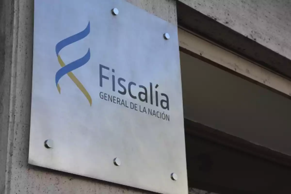 Placa metálica en la entrada de un edificio con el logo y el texto Fiscalía General de la Nación Placa metálica en la entrada de un edificio con el logo y el texto Fiscalía General de la Nación