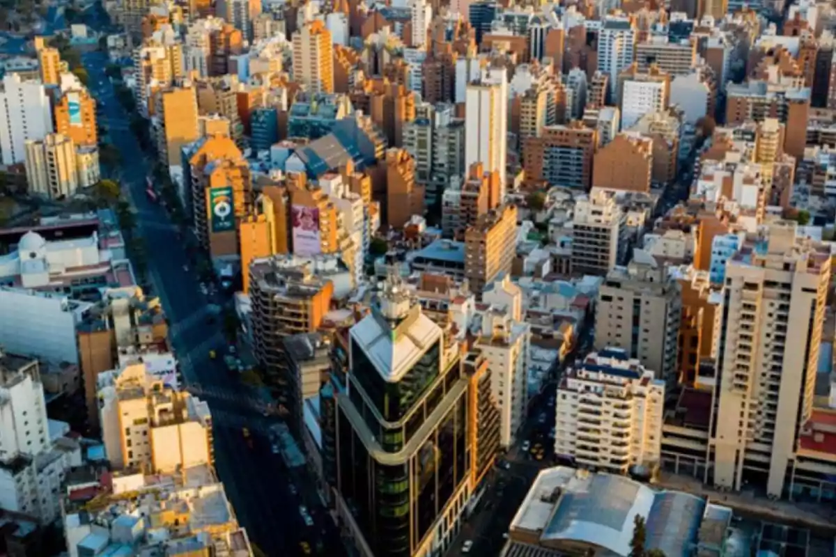 Vista aérea de una ciudad con numerosos edificios altos y calles transitadas en un día soleado