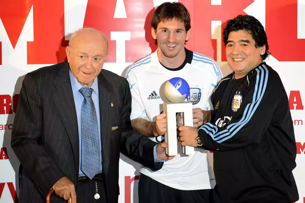 Three people pose together while holding a trophy at an event. Three people pose together while holding a trophy at an event.