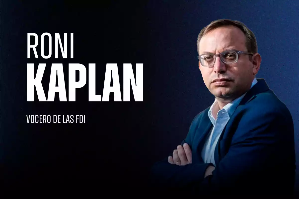 Man with glasses and a blue blazer posing with his arms crossed against a dark background next to the text "Roni Kaplan, IDF spokesperson"