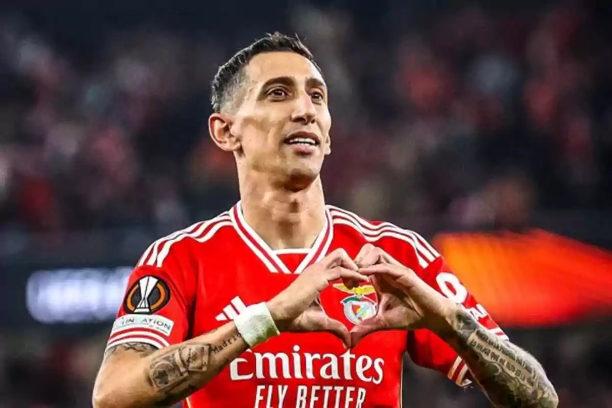 A player in a Benfica uniform makes a heart gesture with his hands during a match. A player in a Benfica uniform makes a heart gesture with his hands during a match.