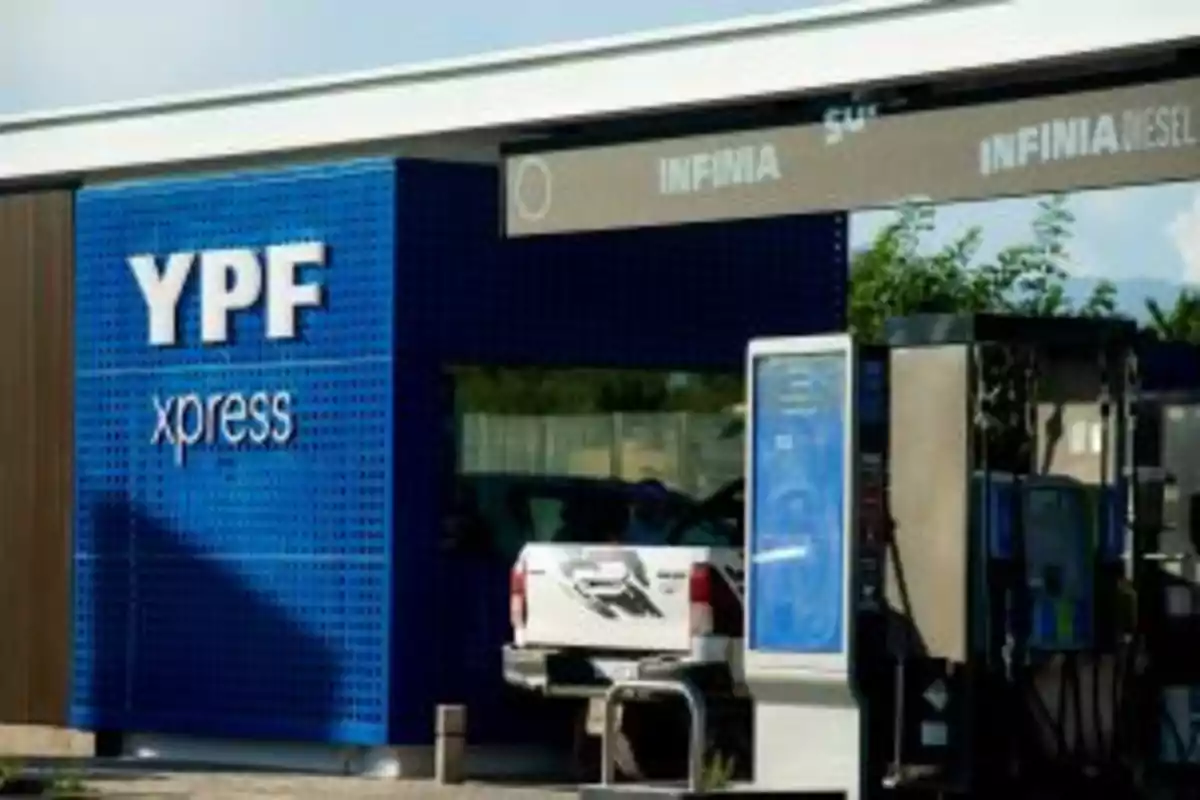 Estación de servicio YPF xpress con una camioneta blanca cargando combustible en una de las bombas