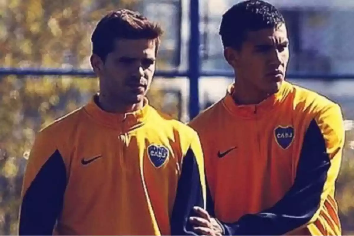 Dos personas con chaquetas deportivas de Boca Juniors están de pie al aire libre.