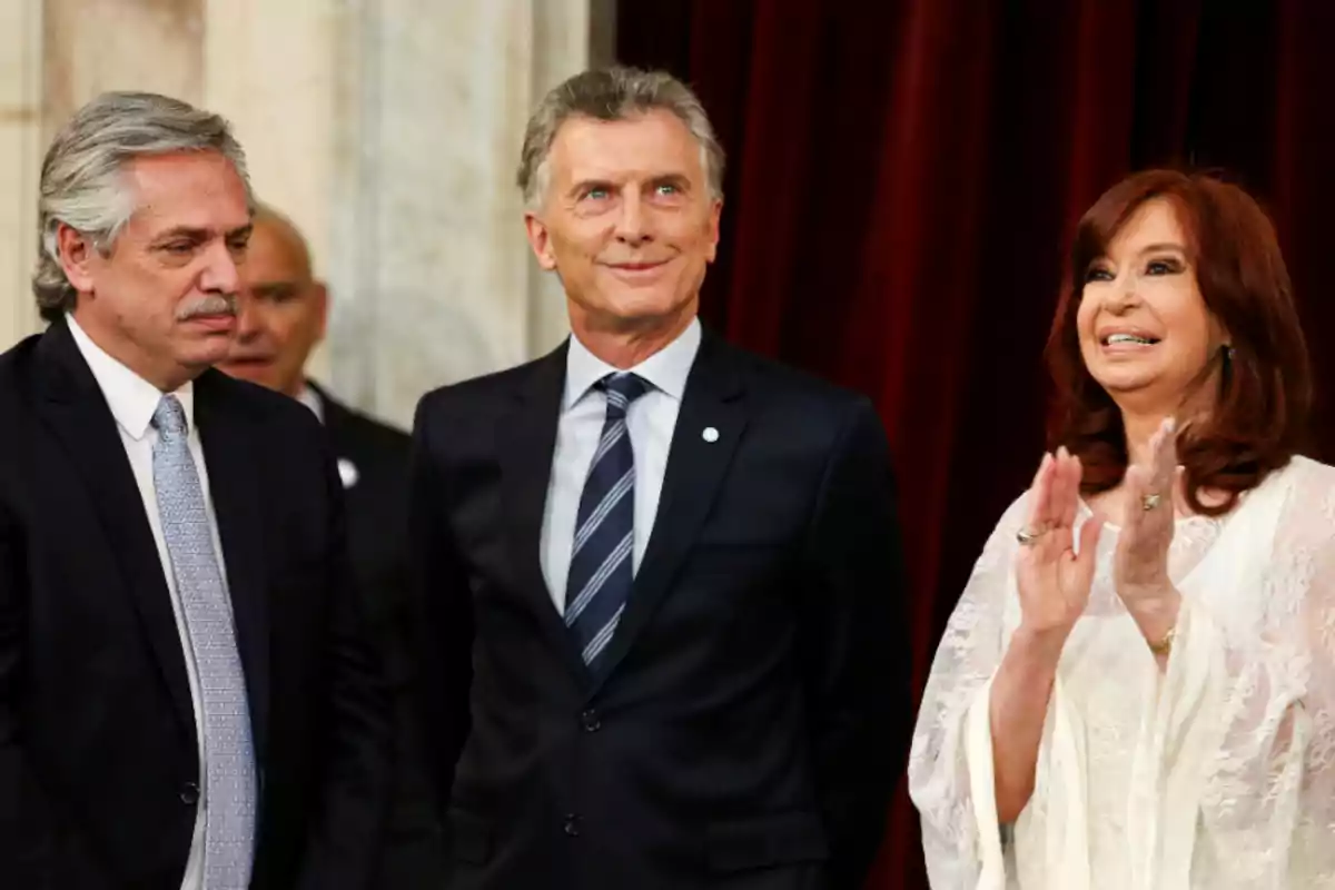 Tres personas vestidas formalmente en un evento.