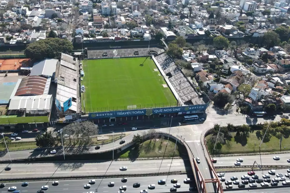 Aerial view of a soccer stadium surrounded by an urban area with streets and buildings. Aerial view of a soccer stadium surrounded by an urban area with streets and buildings.