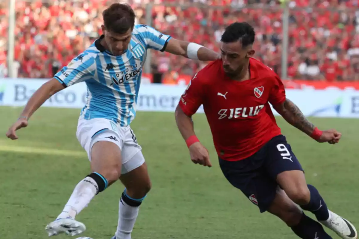 Two players compete for the ball in a match, one wearing a light blue and white striped uniform and the other wearing a red uniform. Two players compete for the ball in a match, one wearing a light blue and white striped uniform and the other wearing a red uniform.