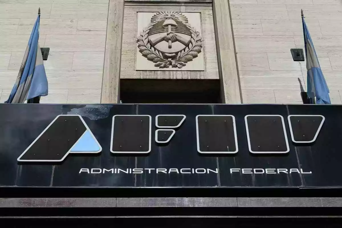 Fachada de un edificio gubernamental con el logo de la Administración Federal y dos banderas argentinas ondeando a los lados.