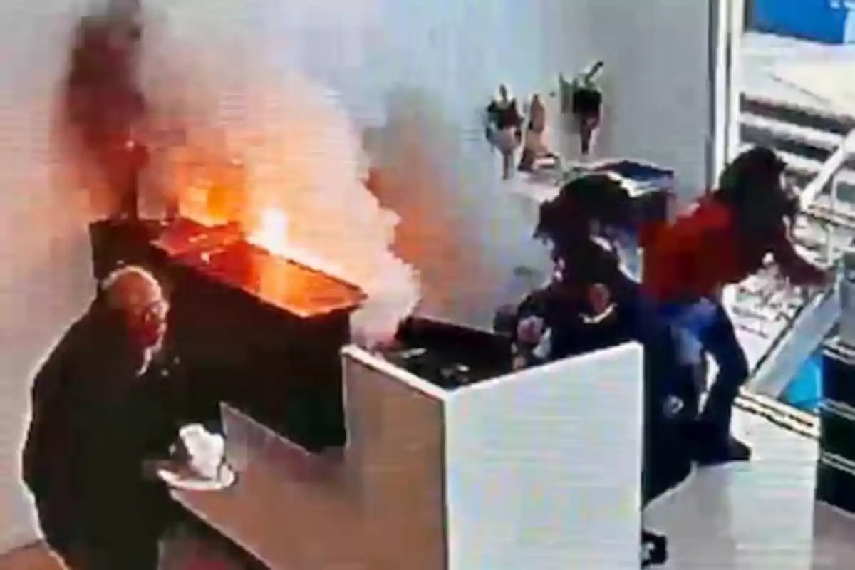 Una escena de un incendio en un interior con personas reaccionando al fuego.