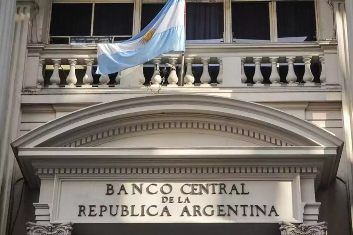 Fachada del Banco Central de la República Argentina con una bandera argentina ondeando en el balcón superior.