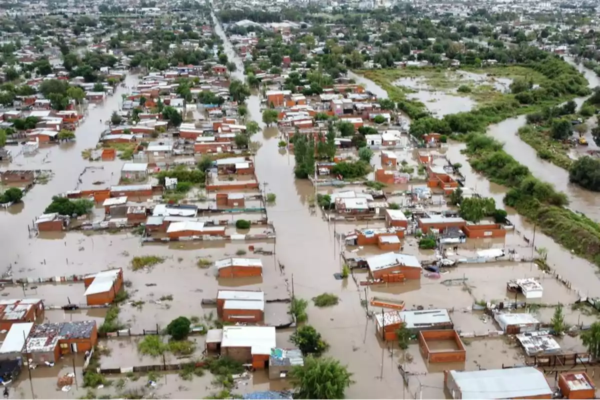 Vista aérea de un área urbana inundada con casas parcialmente sumergidas y calles cubiertas de agua.