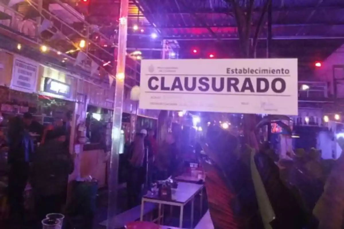 Un bar con luces de colores y un letrero de clausurado en primer plano Un bar con luces de colores y un letrero de clausurado en primer plano