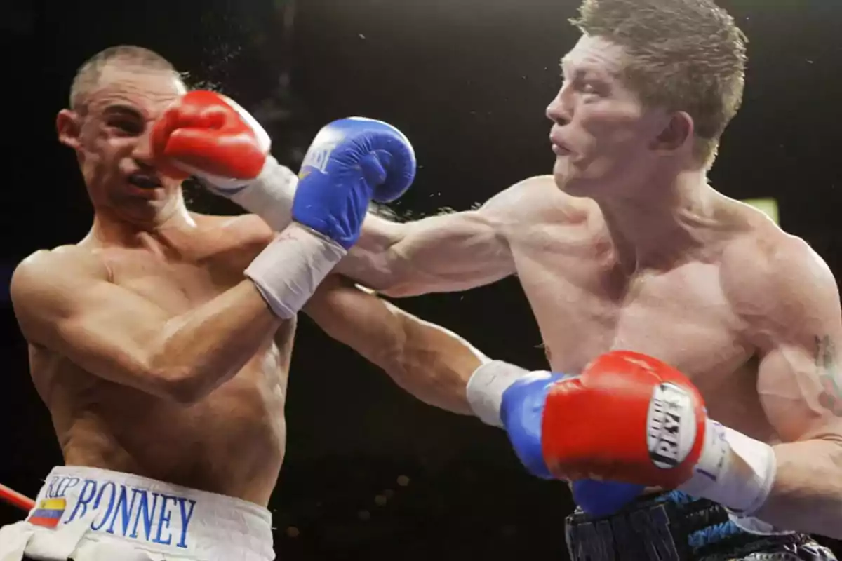 Dos boxeadores en el ring, uno de ellos recibe un fuerte golpe en la cara.