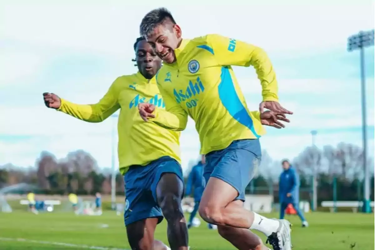 Dos futbolistas entrenando en un campo de fútbol con uniformes amarillos y azules. Dos futbolistas entrenando en un campo de fútbol con uniformes amarillos y azules.