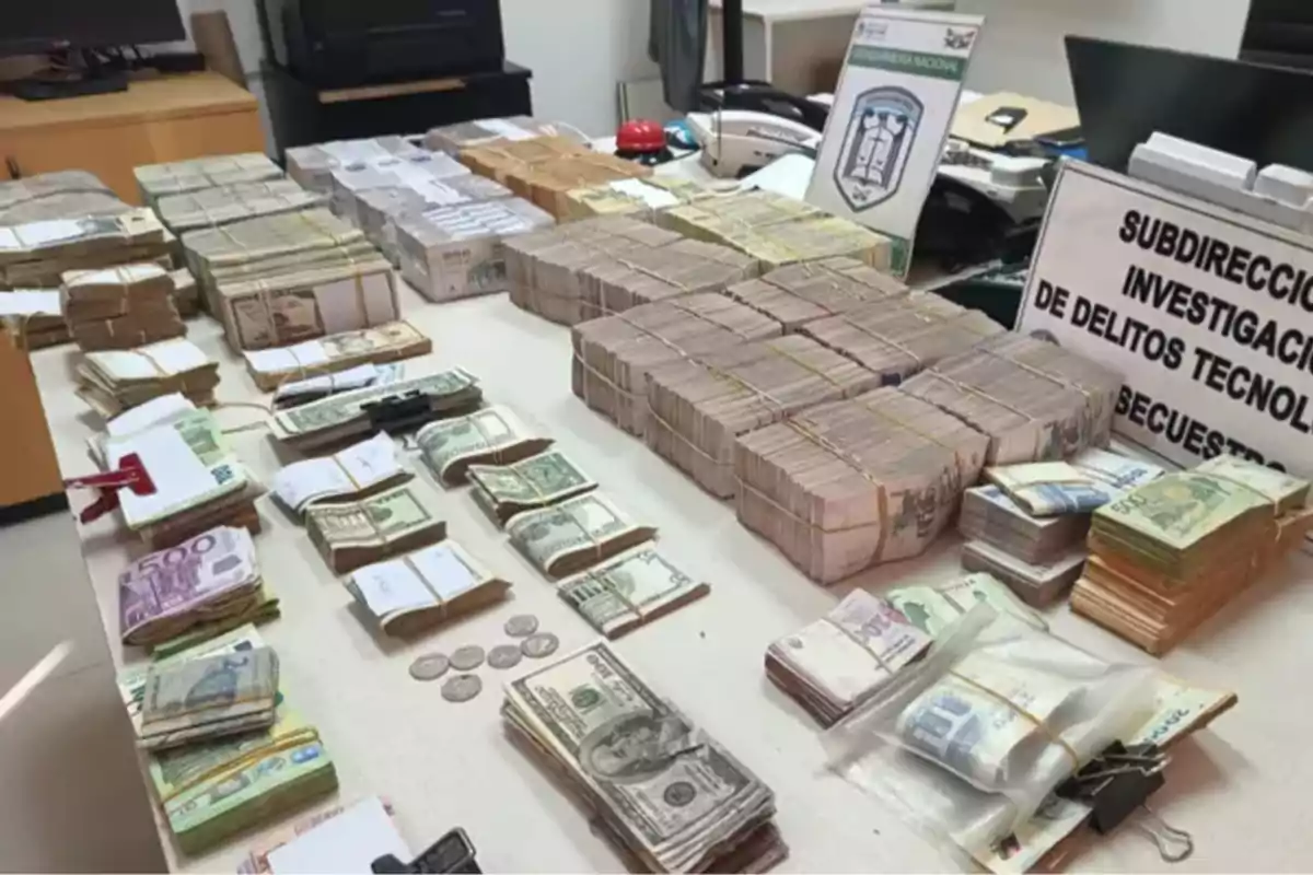 Large amounts of bills of different denominations and coins stacked and organized on a table in a police office Large amounts of bills of different denominations and coins stacked and organized on a table in a police office