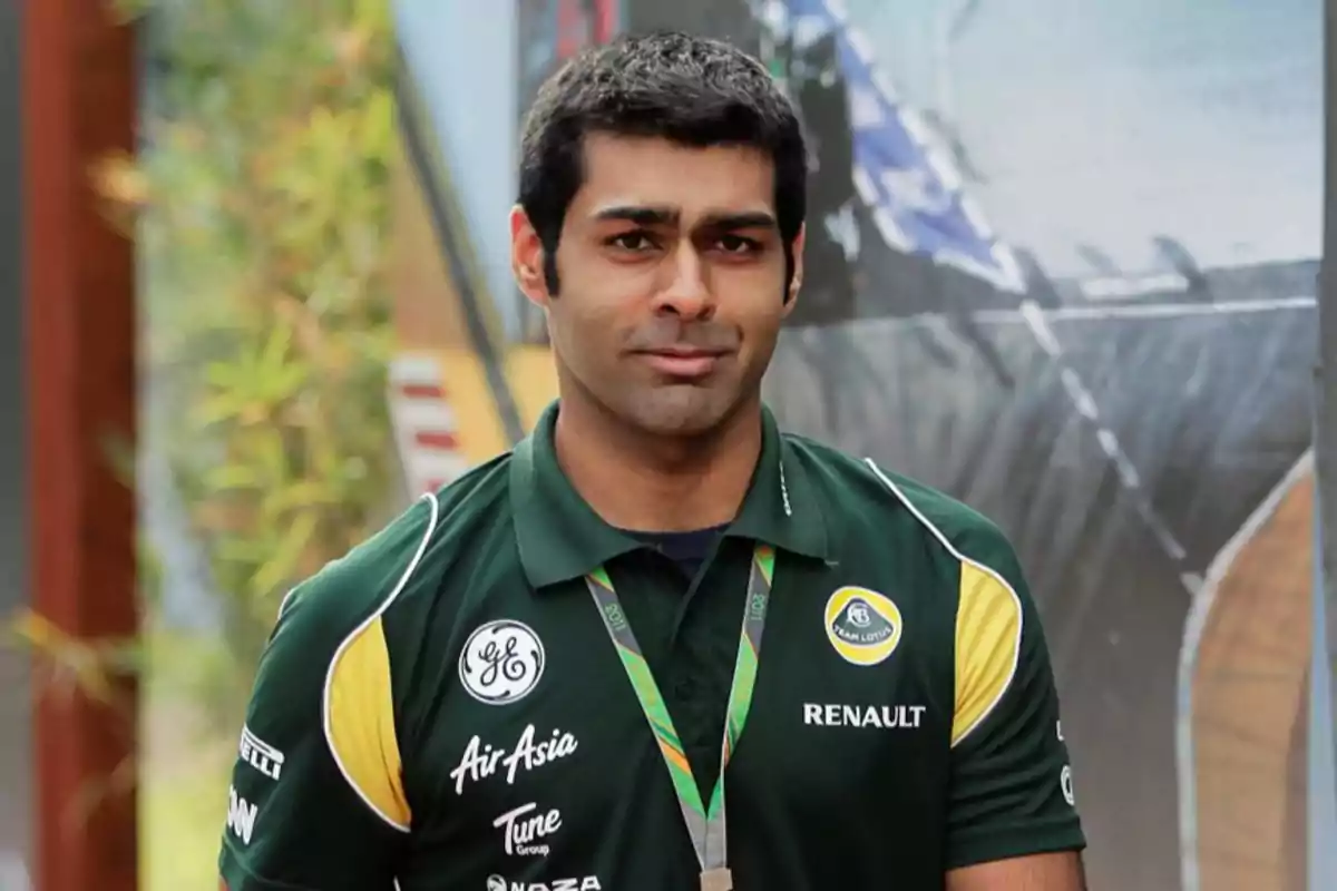 Un hombre con camiseta verde de un equipo de automovilismo, con logos de patrocinadores, posando al aire libre. Un hombre con camiseta verde de un equipo de automovilismo, con logos de patrocinadores, posando al aire libre.