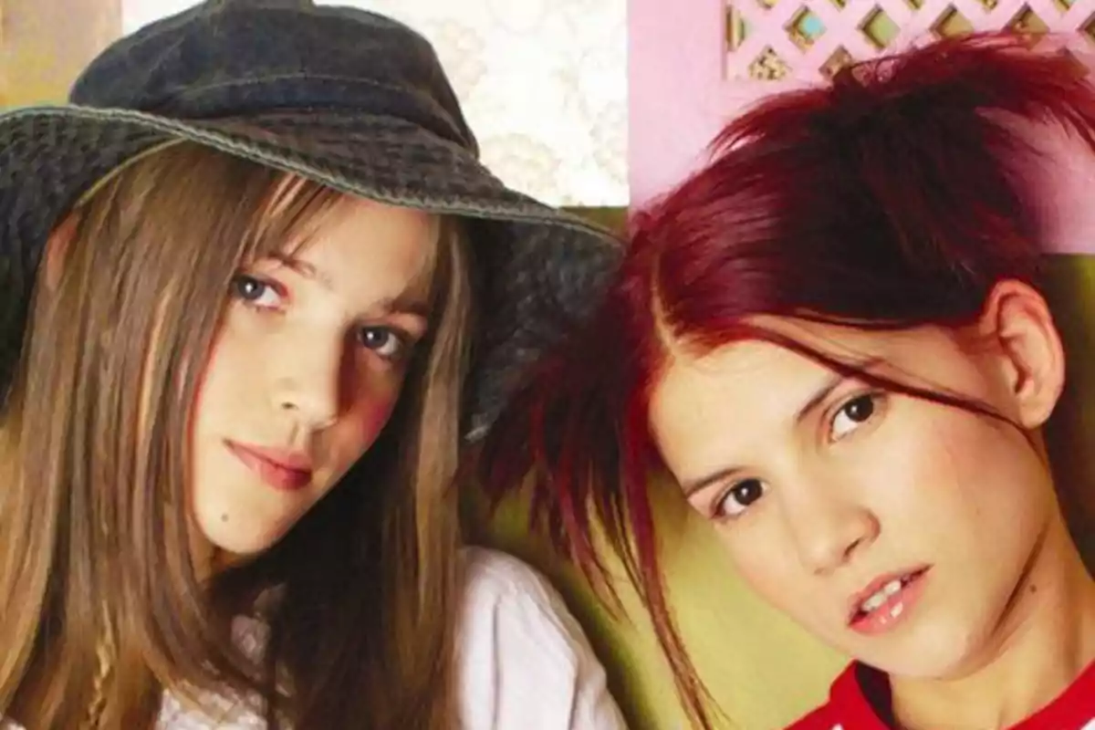 Dos jóvenes posando juntas, una con sombrero y cabello largo castaño, la otra con cabello rojo recogido.
