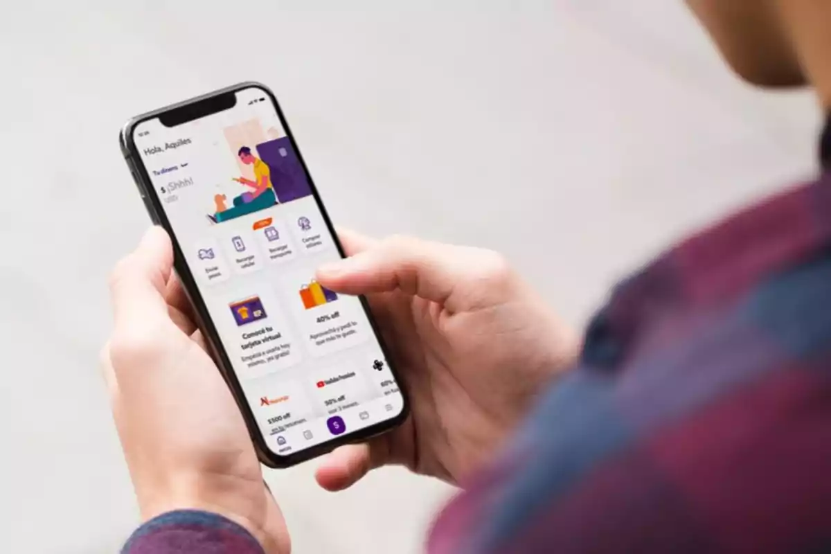 Persona sosteniendo un teléfono móvil que muestra una aplicación con varias opciones en la pantalla.