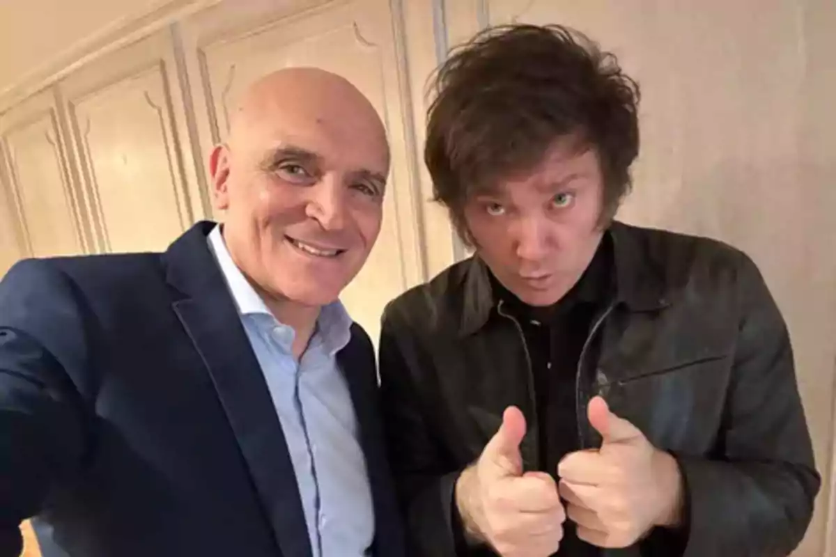 Dos hombres posan juntos para una selfie, uno sonríe y el otro hace gesto de aprobación con ambos pulgares hacia arriba Dos hombres posan juntos para una selfie, uno sonríe y el otro hace gesto de aprobación con ambos pulgares hacia arriba