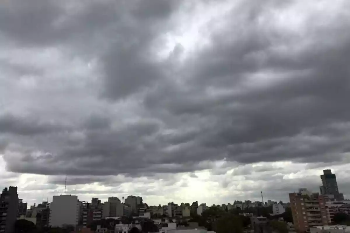 Cielo nublado sobre una ciudad con edificios en el horizonte.