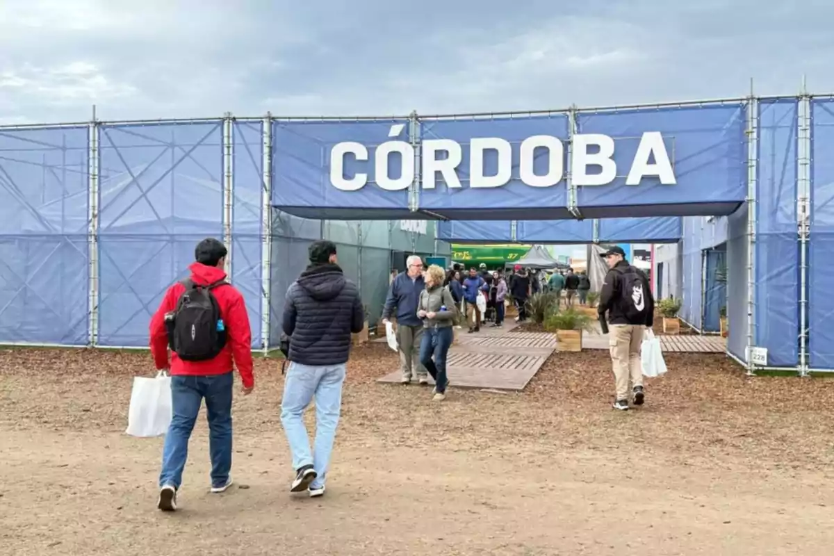 People entering a fairground with a large sign that says Córdoba People entering a fairground with a large sign that says Córdoba